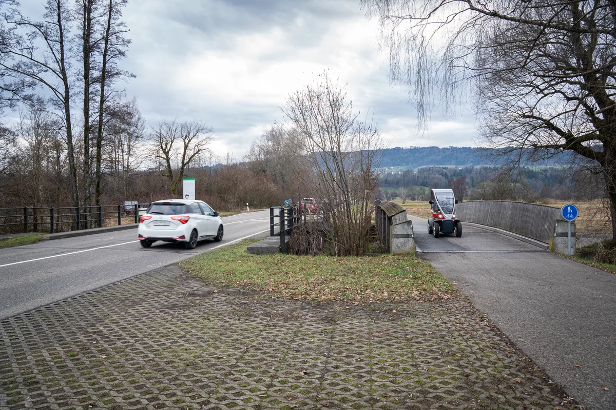 Man sieht verschiedene Verkehrsteilnehmer auf der Strasse und auf dem Veloweg.